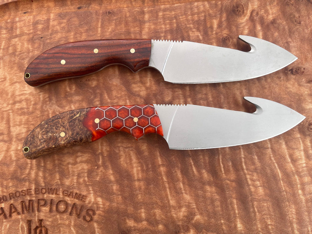Two knives with wooden handles on a wooden surface